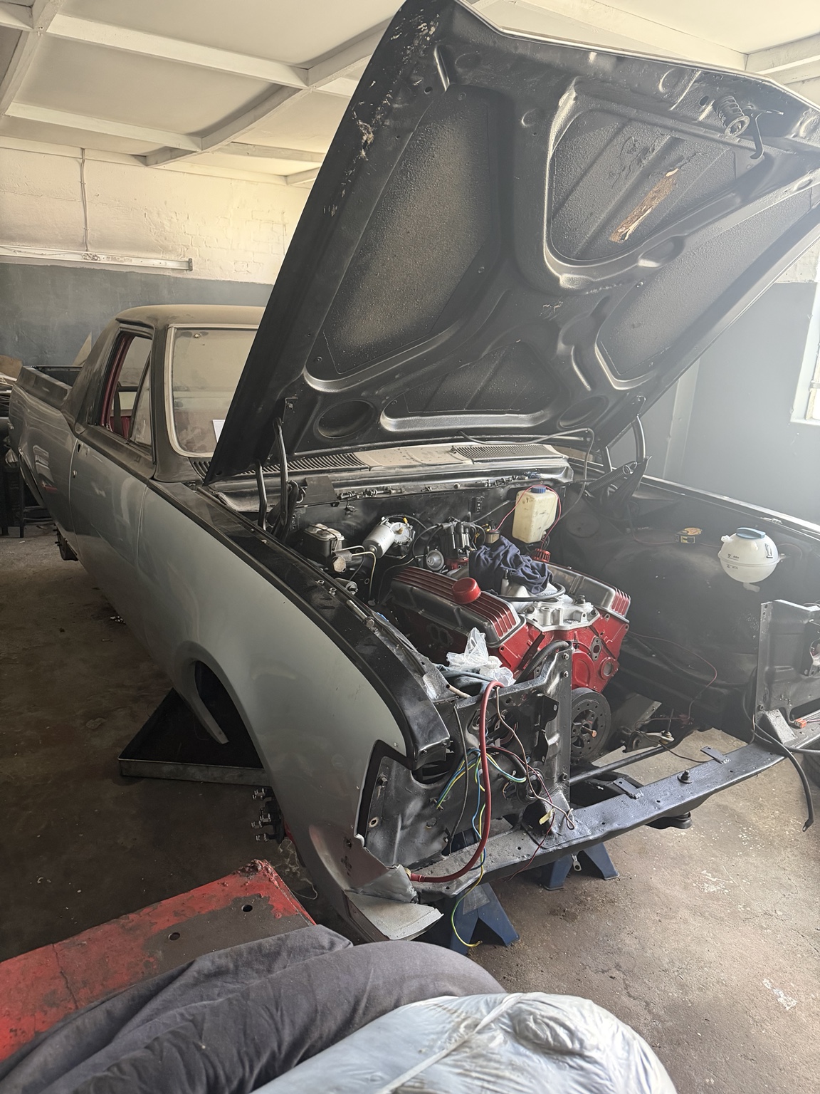 Grey classic vehicle with engine work underway